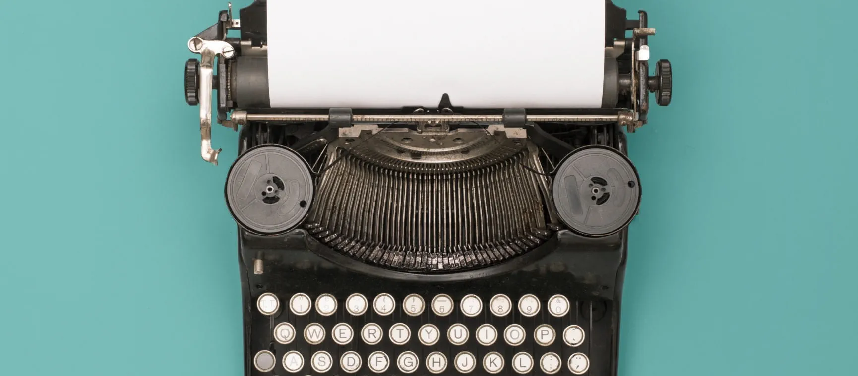 A typewriter sitting on a desk, surrounded by books